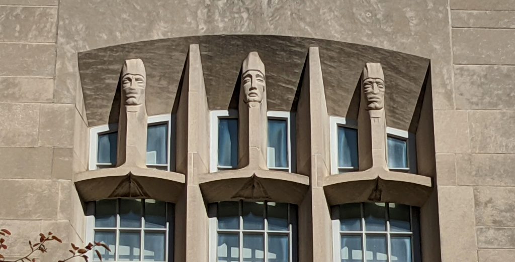 Faces sculpted in limestone look out from the exterior of Myers Hall.