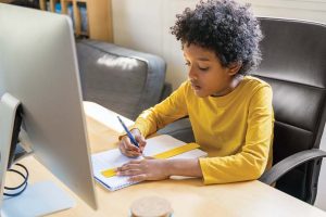 A child does his homework at a home computer.