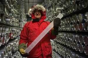 Photo showing book author Zoran Kilibarda, holding ice core at NICL Ice Core Repository, May 23, 2016. Layers in the glacier ice