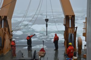 Photo showing four crew members lowering Gravity Corer to the sea floor.