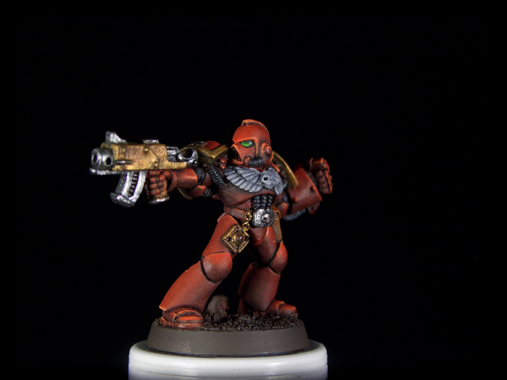 Image of a Blood Angels miniature on black background. Man in full body red power armor.