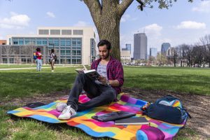 Student reading near Wood Fountain at IU Indianapolis.