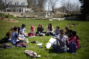 Students participate in an Arabic class, seated in front of Bryan House.