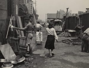 A prostitute walks down a street in postwar Tokyo slum