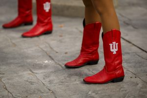 Members of the RedSteppers dance team wear cowboy boots featuring the IU trident during a pep rally near Woodburn Hall at IU Bloomington.