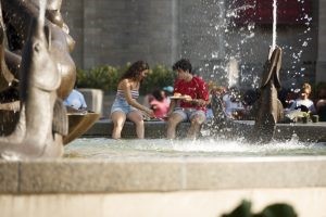 Students eat with their feet in Showalter Fountain during Bikes and Burgers at IU Bloomington.