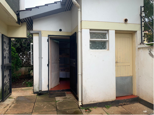 The exterior of a building with an open bedroom door on the left and a closed bathroom door on the right