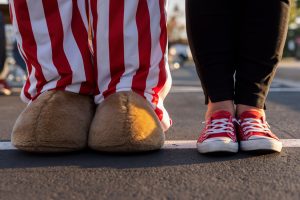 Image of the shoes of a fan standing next to the IU mascot during the homecoming tailgate at Indiana University Kokomo.