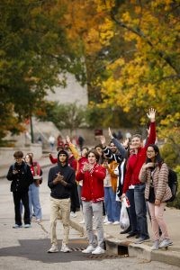 Students and members of the public cheer and react to someone tossing t-shirts into the crowd during a pep rally near Woodburn Hall at IU Bloomington.