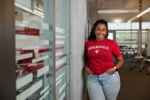 An IU Indianapolis student posing outside of a classroom.