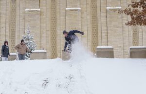 Student launches his snowboard over a hill behind the IU Auditorium at IU Bloomington.