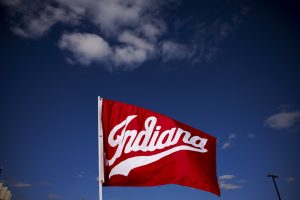 An Indiana University flag flies backdropped against blue skies before the start of the IU Bloomington Homecoming Parade.