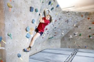 Indiana University student climbs the bouldering wall in Eigenmann Hall at IU Bloomington.