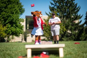 Student playing bags with the IU Fort Wayne mascot.