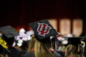 A graduate wears a mortarboard decorated with the IU trident before the Indiana University South Bend Commencement.