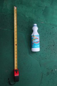 white plastic Clorox bottle about 8.5 inches tall. Clorox label still present, writing is visible, discernable, and in Spanish