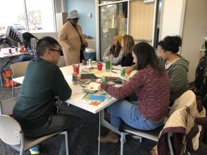 a group pf people gather around a table creating and sharing their toxic heritage stories.