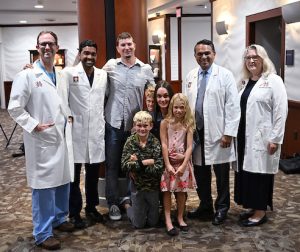 Physicians posing with patient and family