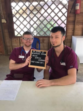 A photo of two people posing with a sign that reads "IUE School of Nursing 2019 Belize Service Learning First Clinic Day".