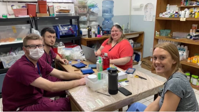 A photo of four people sitting around a table.