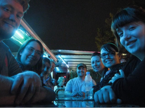 A photo of a group of people posing at a table.