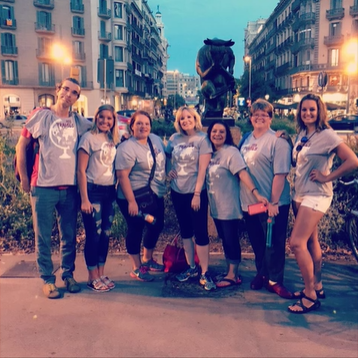 A photo of a group of people posing in front of a fountain.