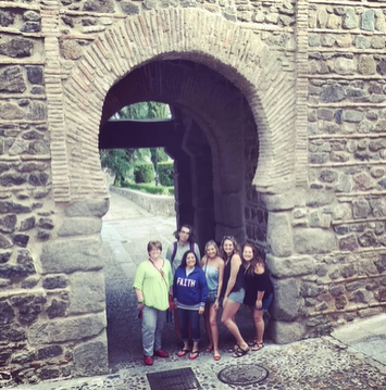 A photo of a group of people posing in an archway.