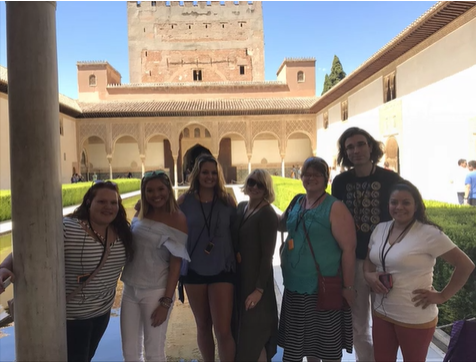 A photo of a group of people posing in a courtyard.