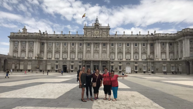 A photo of a group of people posing in front of a building.