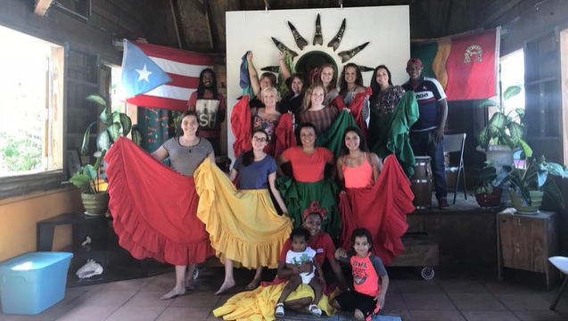 A photo of a group of people posing in front of flags.