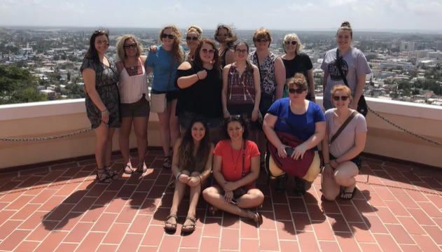 A photo of a group of people posing on a balcony.