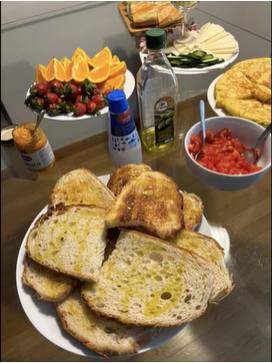 A photo of bread and other foods on a table.