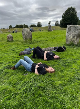 A one photo of four people lying down in a field.