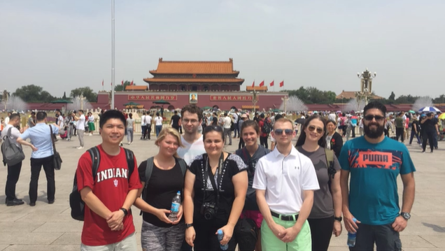 A photo of a group of people posing in front of a building.