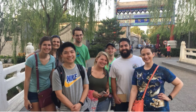 A photo of a group of people posing on a bridge.