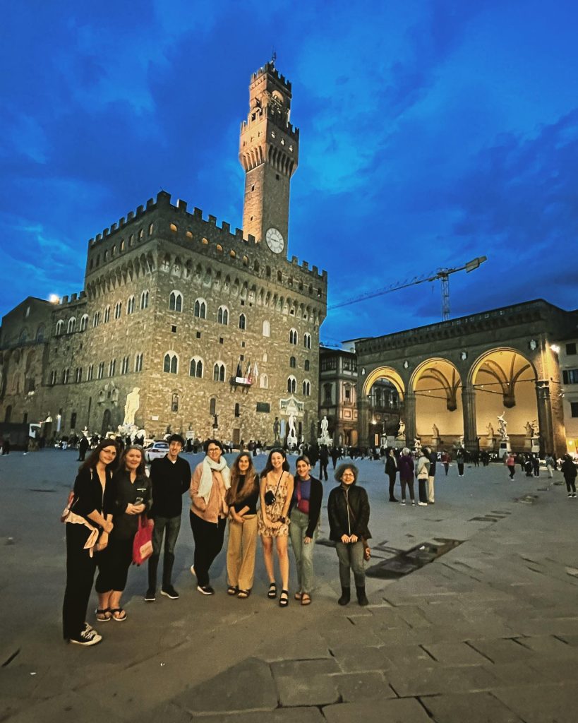 Image of a group of people posing in front of the Piazza della Signoria.