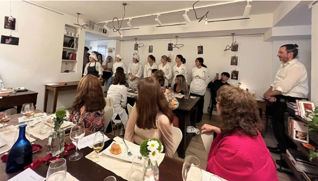 A photo of a group of people watching a group of chefs.