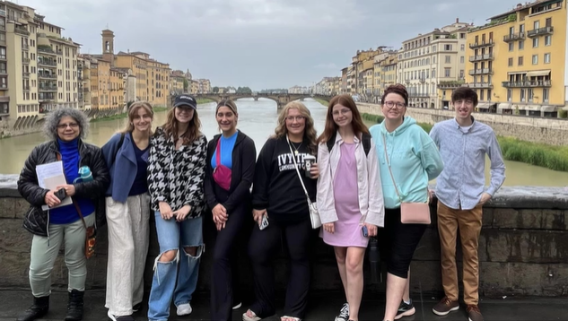 A photo of a group of people posing on a bridge.