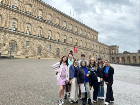 A photo of a group of people posing in front of a building.