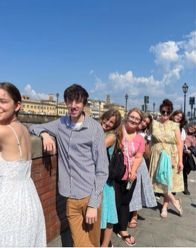 A photo of a group of people standing on a bridge.