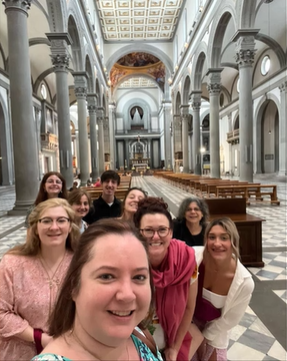 A photo of a group of people posing for a selfie in Basilica di San Lorenzo.