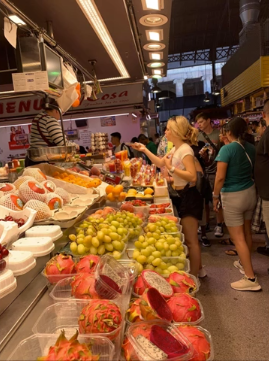 A photo of people purchasing food at a market.