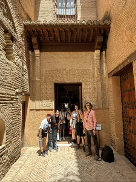 A photo of a group of people posing in front of a building.