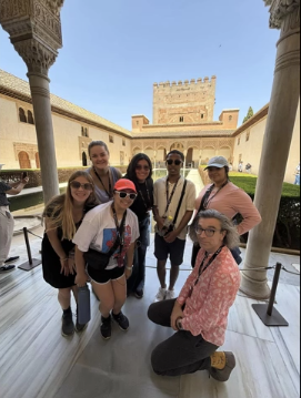 A photo of a group of people posing on a veranda.