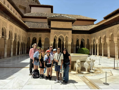 A photo of a group of people in front of a fountain.