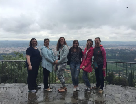 A photo of a group of people posing on a balcony.