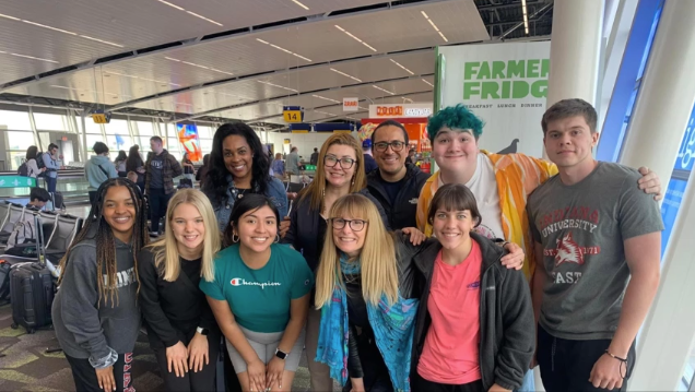 A photo of a group of people posing in an airport.