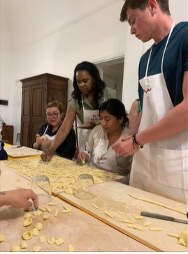 A photo of four people making pasta.