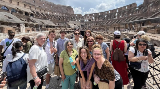 A photo of a group of people inside the colosseum.