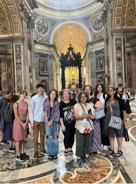 A photo of a group of people posing inside of a detailed building.